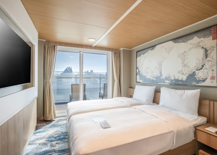 バルコニースイート(12.6㎡)2～3名様：広々とした寝室と専用バルコニーが調和した部屋 いつでもバルコニーから海の景色を眺めながらプライベートな休息を楽しめるキャビンです。ディナーは専用席にてビュッフェ料理の他特別食をご用意いたします